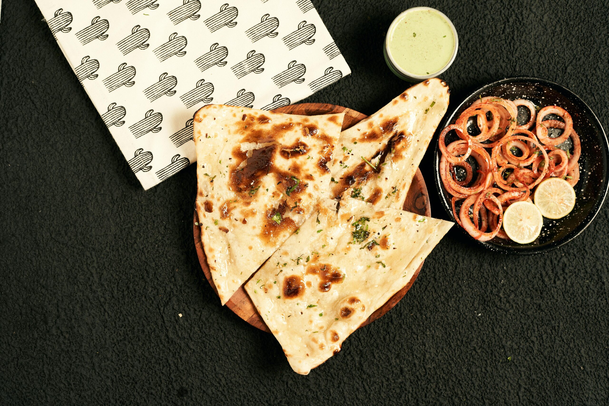 Close-up of Indian naan served with onion rings and green chutney, perfect for food stock images.
